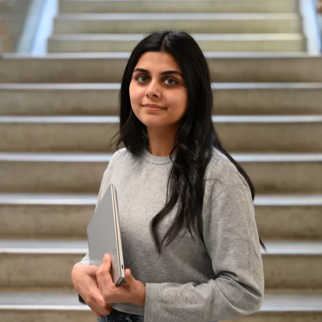 KPU student Akshleen Kaur standing in the library.