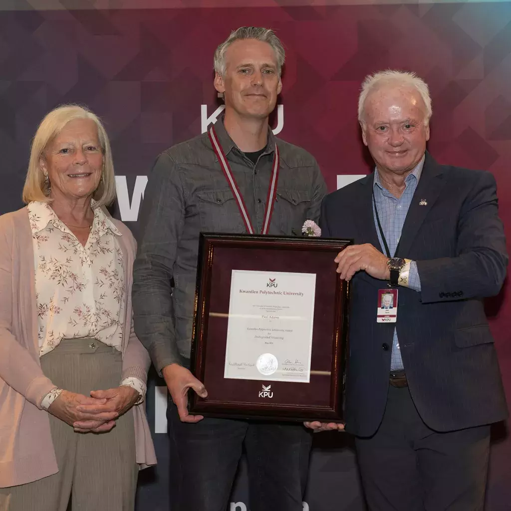 : Dr. Paul Adams, centre, receives his Distinguished Scholarship Award from Dr. Deborah Henderson, Director of the Institute for Sustainable Horticulture, and Dr. Alan Davis, KPU President and Vice-Chancellor.